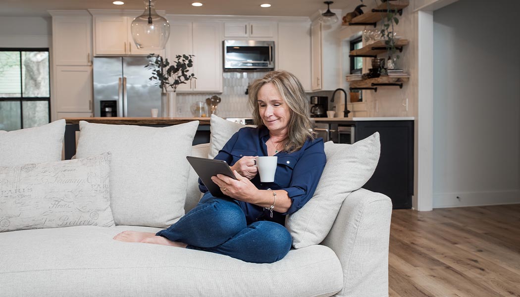 woman on couch upgrades hvac for comfort