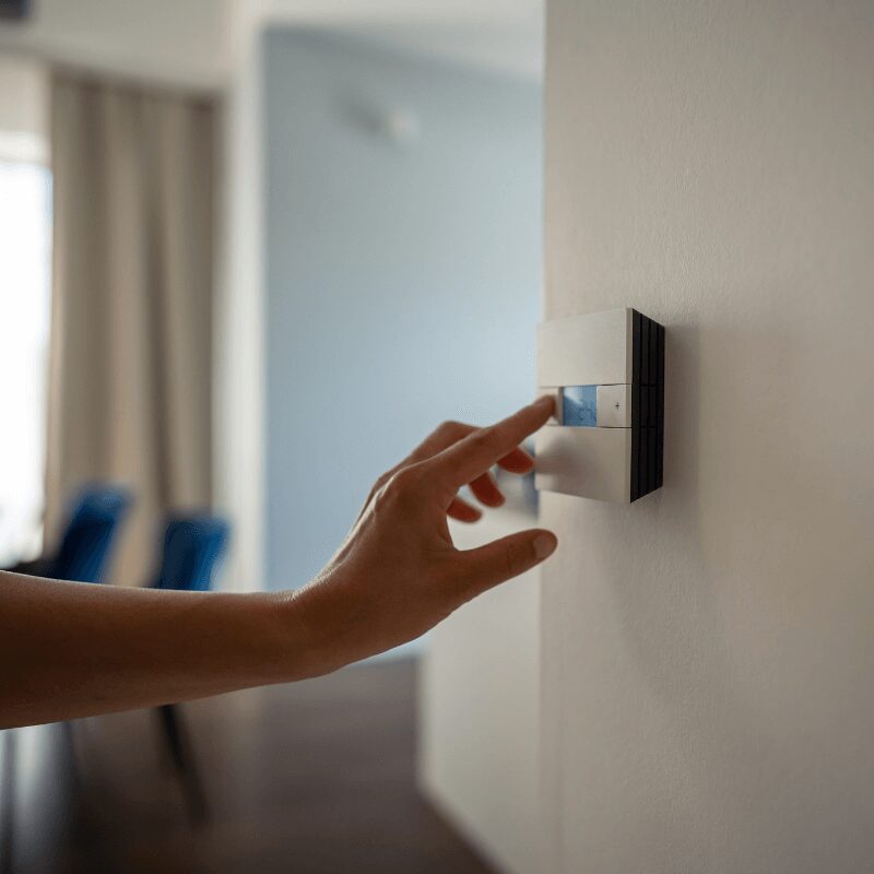 woman-hand-adjusts-underfloor-heating-setting woman’s hand adjusting heating settings